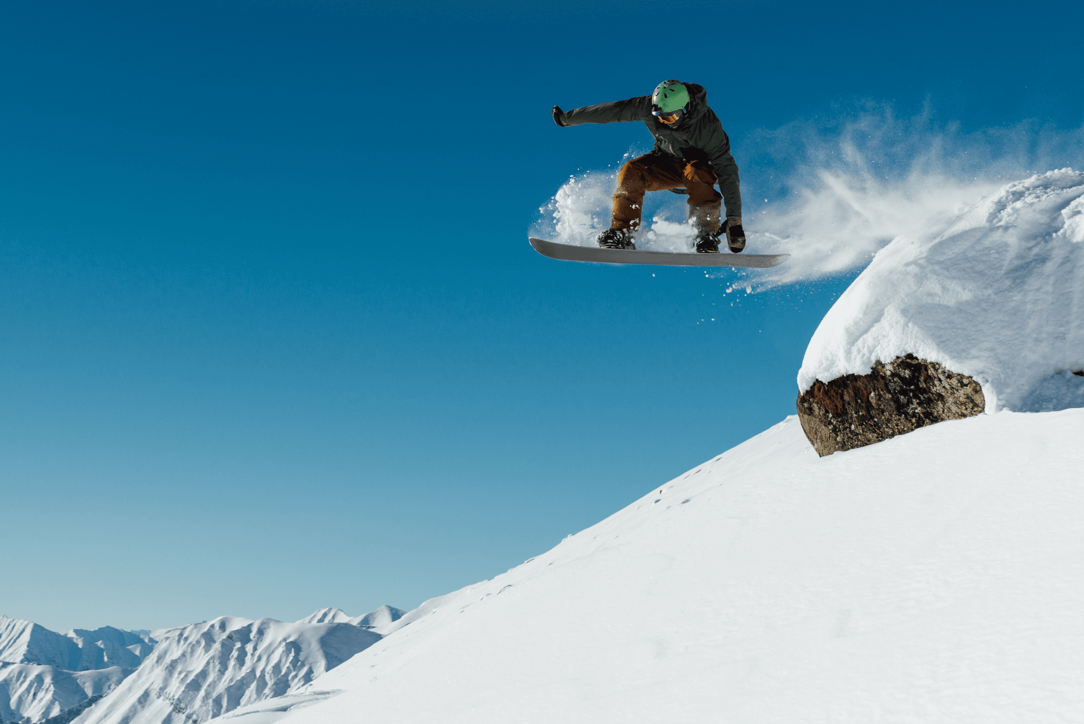 A snowboarder mid-air against a clear sky